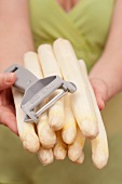 Hands holding peeled white asparagus