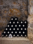 A stack of wine bottles in a niche in a wall