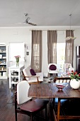 Open-plan living-dining room with white-upholstered seating and ceiling fan