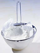 Ricotta being drained in a cloth and sieve