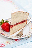A slice of sponge cake filled with strawberry jam