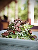 Sliced Sirloin Steak Over a Salad of Romaine Lettuce, Grape Tomatoes, Walnuts, Asparagus and Blue Cheese Dressing