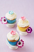 Drei Cupcakes mit Blütendekoration