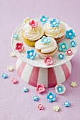 Three cupcakes in a sea of sugar flowers