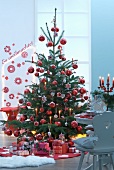 Rot geschmückter Tannenbaum mit vielen Geschenken
