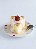 A slice of sponge cake topped with cream and strawberries