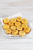 Fried plantain sliced drying on a kitchen paper