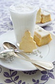 Hot milk with cinnamon and honey, a slice of cake and a biscuit