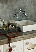 Washstand with square basin against grey partition
