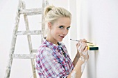 Renovating - woman with spirit level and pen
