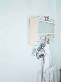 Ausschnitt einer schlichten Küche mit aufgehängtem Küchenboard und Küchenutensilien