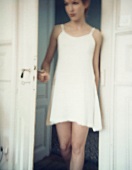A young woman in a neglige standing in a doorway