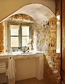 Craggy charm - masonry washstand in window niche with rough stone walls
