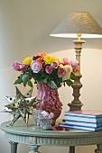 Bunch of flowers, table lamp, decorative star and books on table