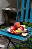 Nectarines and peaches on a plate on a garden chair