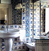Traditional bathroom with pedestal sink against white and blue wall tiles and mirror lamp with white shade