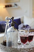 Soda dispenser, carafe and glass with red wine
