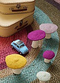Deko Pilze aus Filz und Spielzeugauto auf Teppich