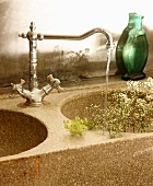 Schleierkraut im Steinbecken eines Waschtisches mit Vintage Wasserhahn