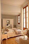 Schmales Schlafzimmer mit Möbeln im Stilmix vom Rokoko Nachttisch über Fifties Schalenstuhl zum Bauernschrank