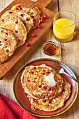 Cranberry Pancakes on a Plate and Cutting Board; Glass of Orange Juice and Maple Syrup