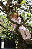 Girl sitting in a tree in garden