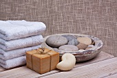 Spa - soaps and towels next to bowl of pebbles