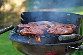 Pork neck steaks on a barbecue