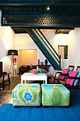 Elegant upholstered stools and white table in modern living room with traditional, wooden staircase