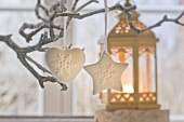 Christmas decorations hanging on tree and candlelit lantern