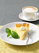 A slice of lemon tart and a cup of cappuccino