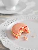 A pink macaroon with a bite taken out