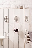 White wooden wall with hooks and gingerbread heart