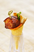 A wafer cone filled with chicken wings and porcini mushrooms