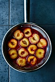 Fried plums in a pan (seen from above)