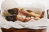 Two skinned Japanese cherry salmon with heads on a bed of vegetables
