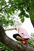 Blonde girl climbing a tree