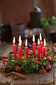 A box wreath with candles, chestnuts, cinnamon sticks and Christmas baubles