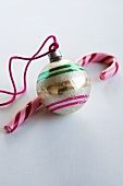 A Christmas tree bauble and a candy cane
