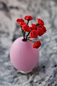 Rosafarbenes Ei mit Dekorosen in Miniaturform