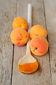 Apricots and apricot jam on a wooden spoon