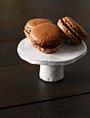 Three chocolate macaroons on a cake stand