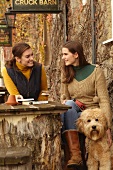 Women with dog having beer at cafe