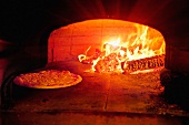 Pizza baking in wood burning oven