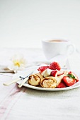 Strawberry Crepes on a Plate with Fork and Knife; Cup of Coffee