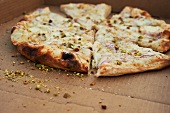 Wood Fired White Pizza with Red Onion, Rosemary, Pistachios and Cheese; Sliced in Box
