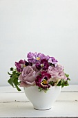 Ein Blumenstrauß aus violetten Stiefmütterchen & Duftrosen