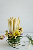 A bunch of white asparagus tied with pansies