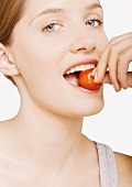 Woman biting into cherry tomato