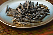 Twists of tea leaves on small plate